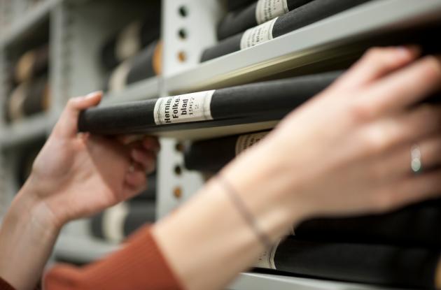 Hardcover original newspapers are taken off the shelf