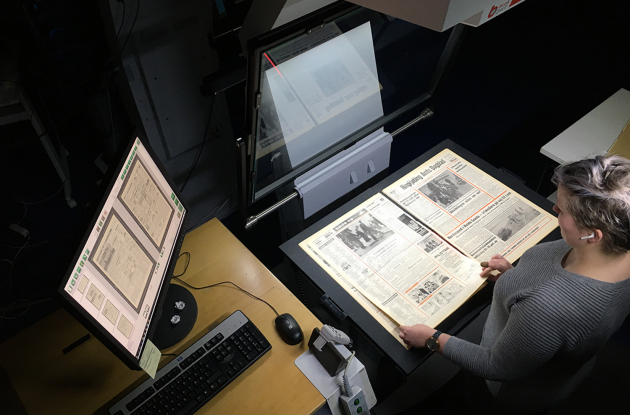 Employee in the process of digital newspaper photography