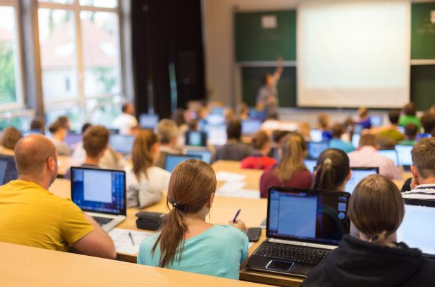 Studerende med laptops i foredragssal