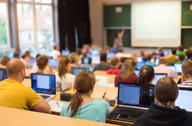 Studerende med laptops i foredragssal 