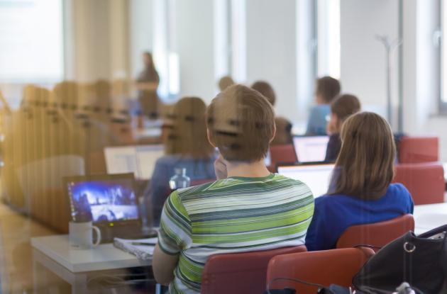 Students with laptops in meeting room