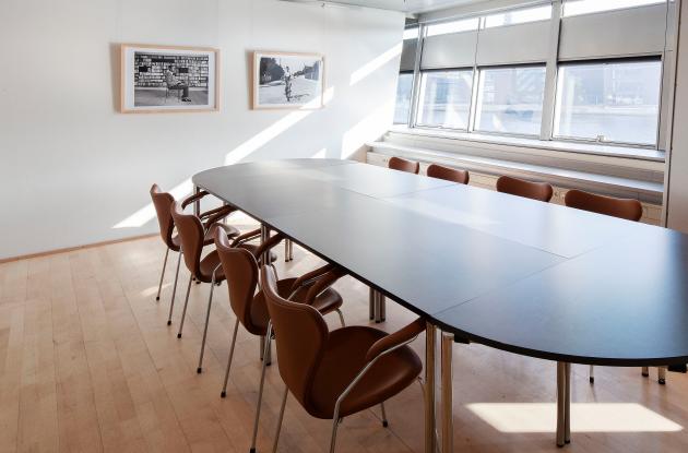 Bord, stole og billeder i mødelokalet Rifbjerg